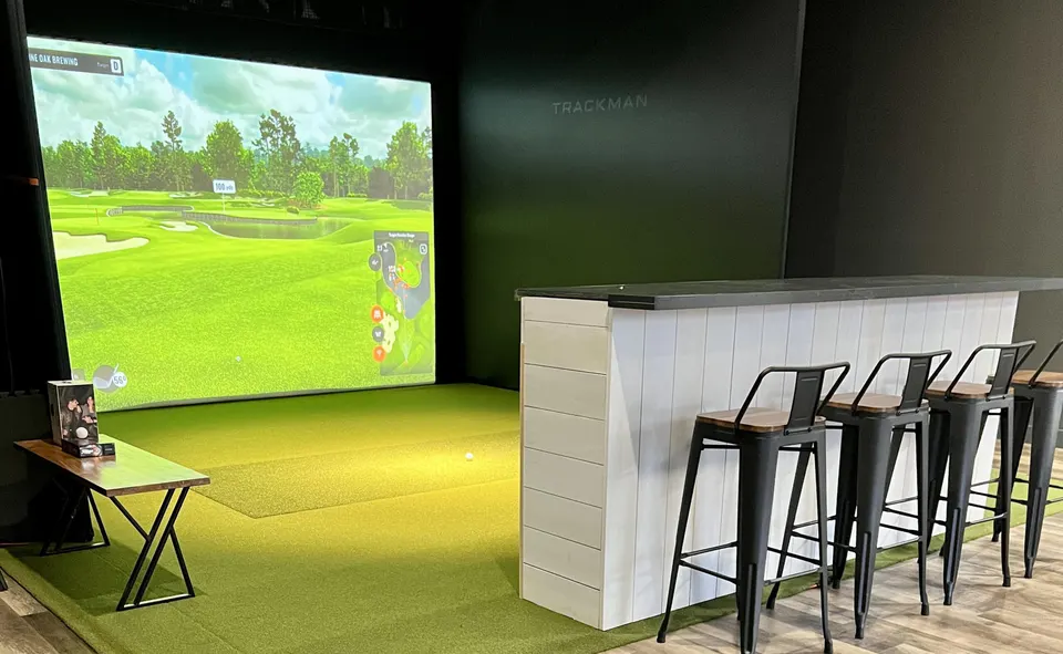 Trackman golf simulator bay with bar seating at the Lone Oak Brewery Taproom