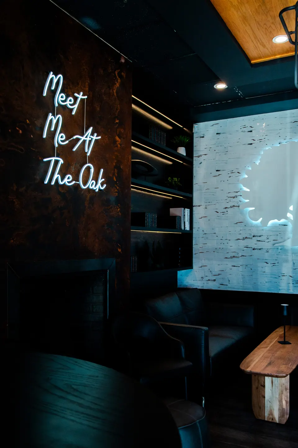 Dark wood interior of The Oak Downtown with a neon Meet Me At The Oak sign